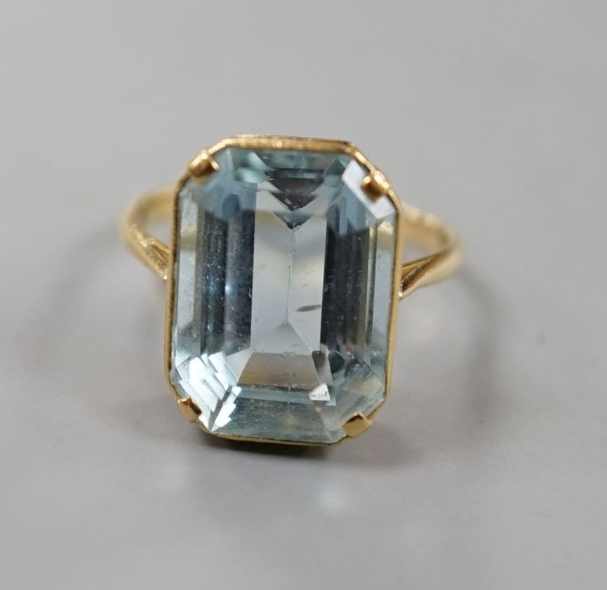 A yellow metal and single stone emerald cut aquamarine set dress ring, size K/L, gross 5.8 grams.